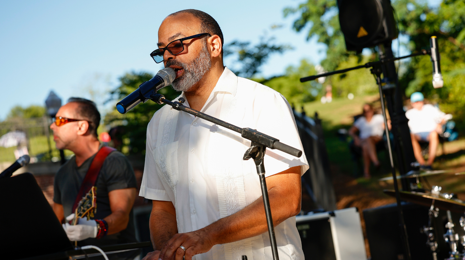 A man wearing sunglasses plays a keyboard and sings at the First Friday concert series in downtown Kennesaw's Main Street Plaza.