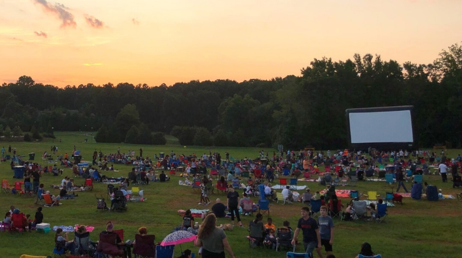 People watch a movie in a field at Swift-Cantrell Park, part of the City of Kennesaw Outdoor Movie Series.