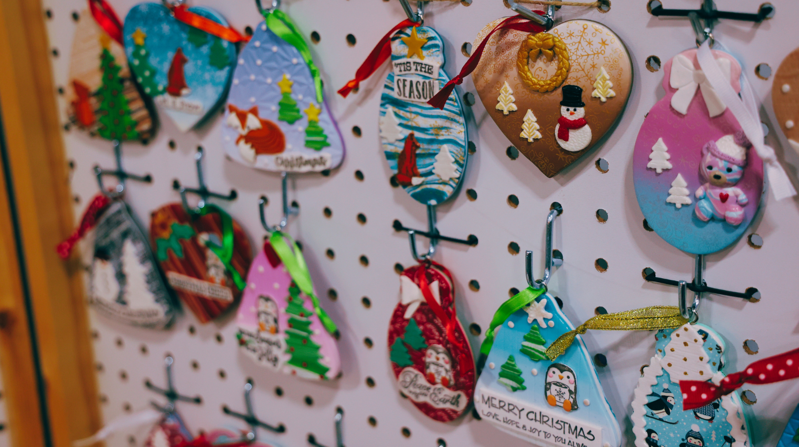 A display of diverse Christmas ornaments on a wall at the Kennesaw Holiday Market.