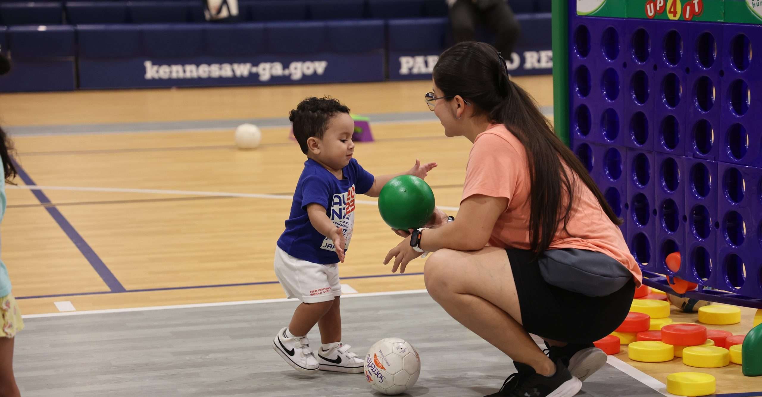 A mom with her toddler playing in a gym