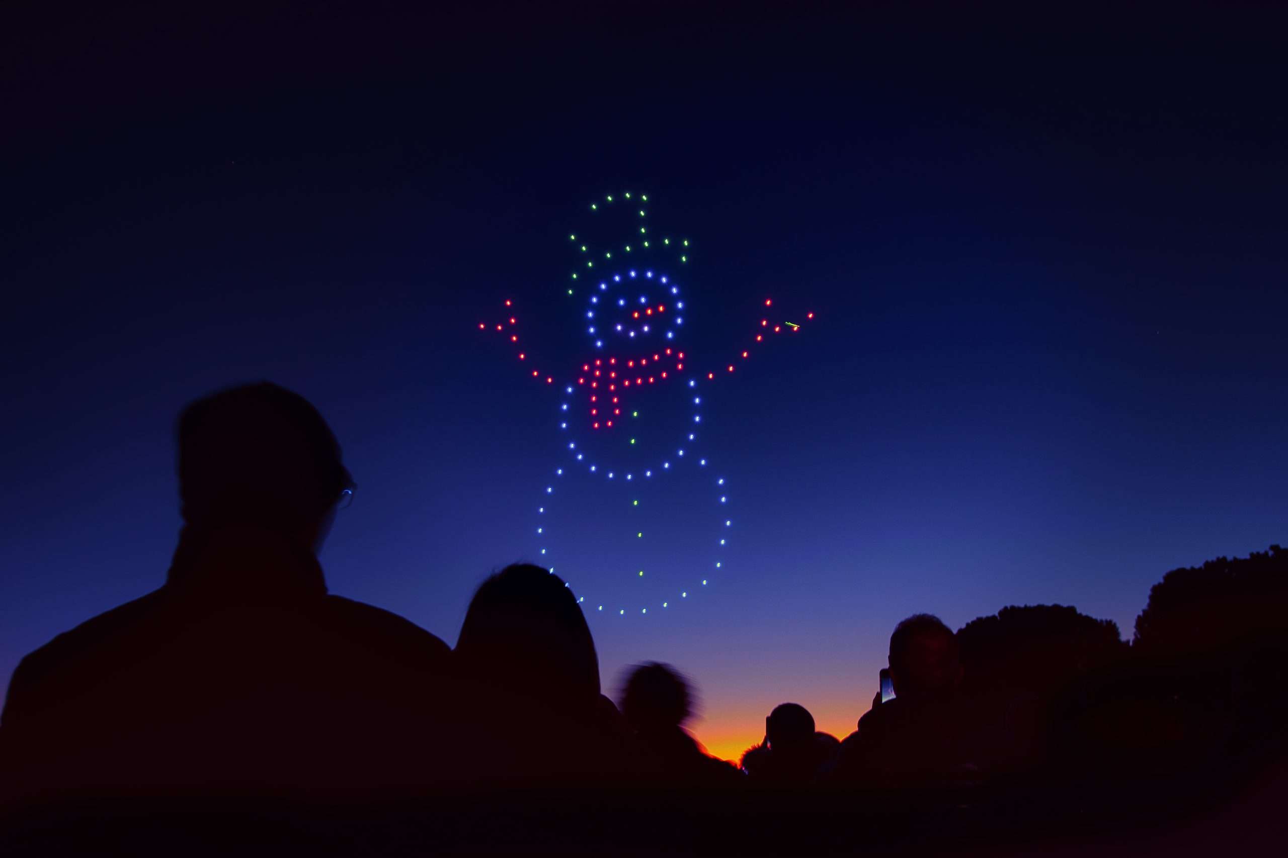 Snowman drawn with drone lights in the night sky